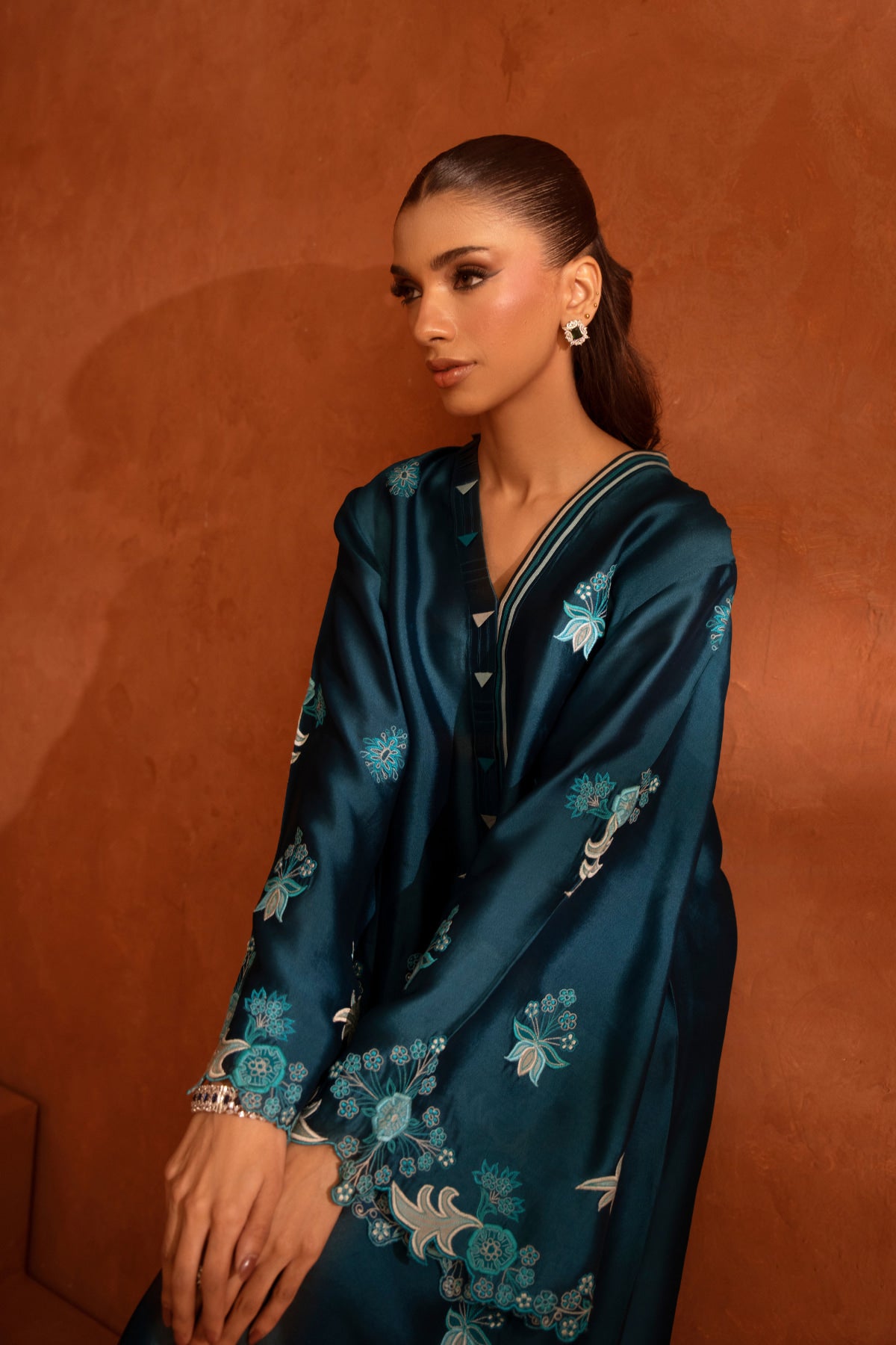 Woman wearing a blue floral dress against an orange background